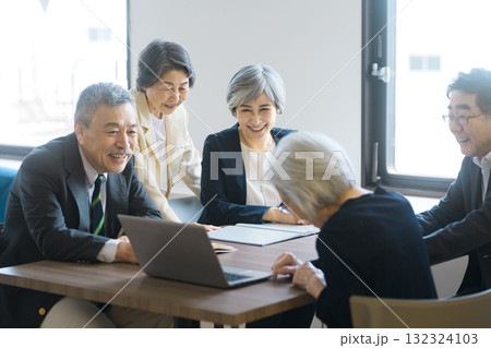 ノートパソコンを囲んで会議をするシニアチーム 132324103