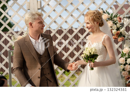 Couple exchanges vows in a beautiful outdoor wedding ceremony Couple exchanges vows in a beautiful outdoor wedding ceremony 132324381