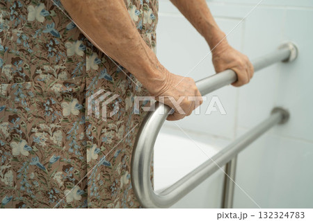Asian elderly woman patient use handrail safety in toilet support rail in bathroom. Asian elderly woman patient use handrail safety in toilet support rail in bathroom. 132324783