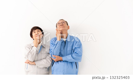 作業着のシニア夫婦 悩む 作業着のシニア夫婦 悩む 132325403