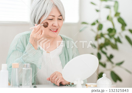チークブラシ,フェイスブラシでメイクするグレーヘアのシニアのアジア人女性 チークブラシ,フェイスブラシでメイクするグレーヘアのシニアのアジア人女性 132325843