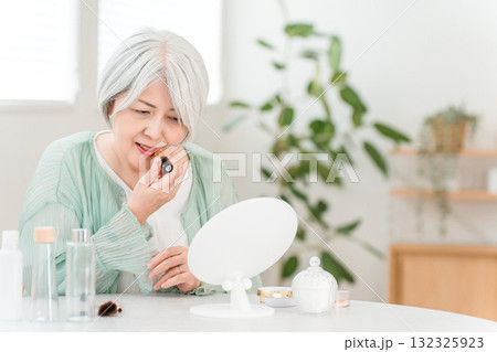 メイクをするグレーヘアーのシニアのアジア人女性（口紅・ルージュ・グロス・リップ） 132325923