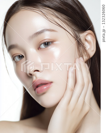 美容液を塗って肌に潤いがある女性の顔のアップ 132326060