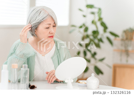 髪の毛をヘアセットする高グレーヘアーのシニアのアジア人女性 132326116