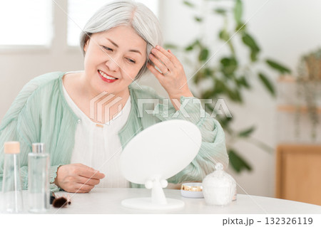 髪の毛をヘアセットする高グレーヘアーのシニアのアジア人女性 132326119