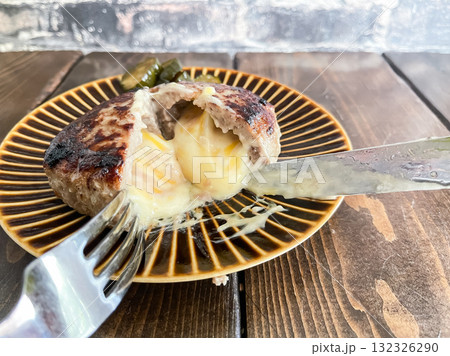 チーズハンバーグ。カットした断面からチーズがとろけ出るハンバーグ。 チーズハンバーグ。カットした断面からチーズがとろけ出るハンバーグ。 132326290