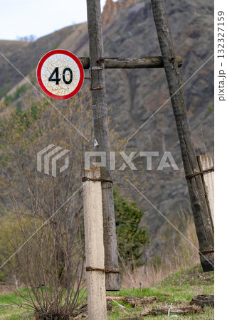 A road sign on a wooden post at the edge of a country road. 132327159