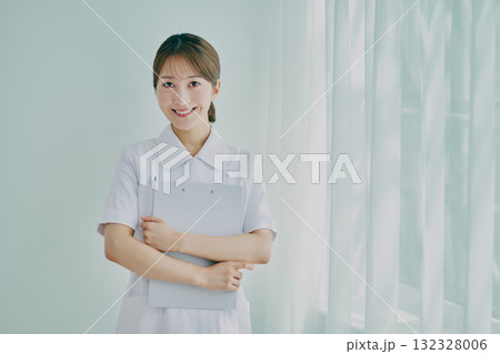 窓際に立っている女性看護師 132328006