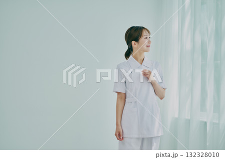 窓際に立っている女性看護師 窓際に立っている女性看護師 132328010