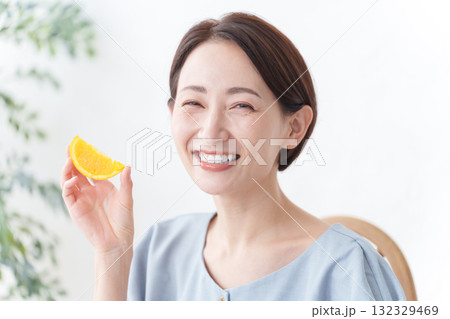 フルーツのオレンジを食べる女性 132329469