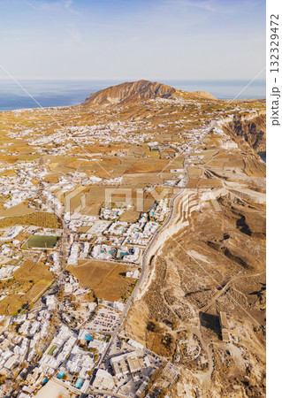 Drone photo capturing the expansive volcanic landscape and scattered white villages of Santorini 132329472