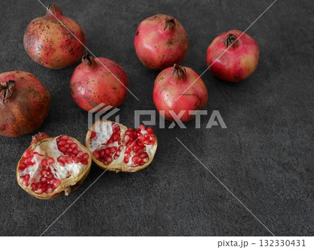 複数の日本のざくろ、一つのざくろは割れている、グレーの背景、右下に余白 132330431