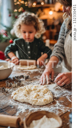 A child stands on a chair helping with Christmas cookies while a woman rolls out dough on a floured countertop 132330451