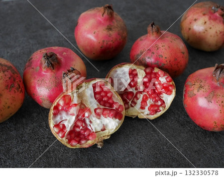複数の日本のざくろ、一つは半分に割れている、グレーの背景 複数の日本のざくろ、一つは半分に割れている、グレーの背景 132330578