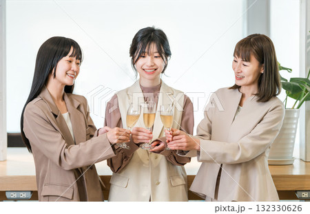 シャンパンを持ってオフィスに並ぶビジネスウーマン（チームワーク,決起集会,祝勝会,お祝い） 132330626
