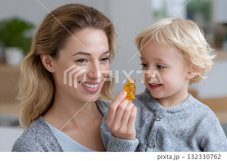 Happy Mother and Child Holding Vitamin Capsules Bottle 132330762