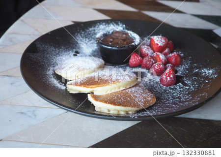 Pancakes with chocolate and strawberries at cafe 132330881