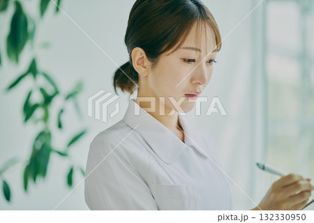 カルテを書き込む女性看護師 カルテを書き込む女性看護師 132330950