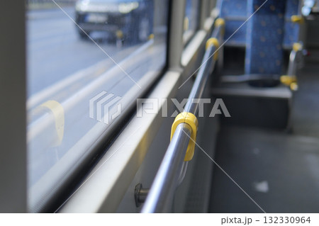 Bus interior with handrails and view of street outside 132330964