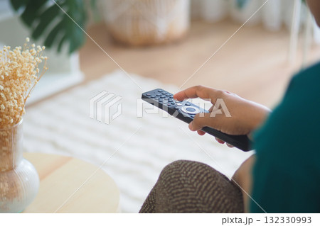 Enjoying a relaxing evening at home with a remote control 132330993