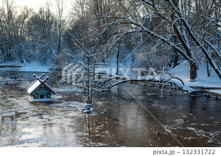 spring floods and ice melt in a small river, waterfowl feeder flooded as water level rises, Dobele 132331722