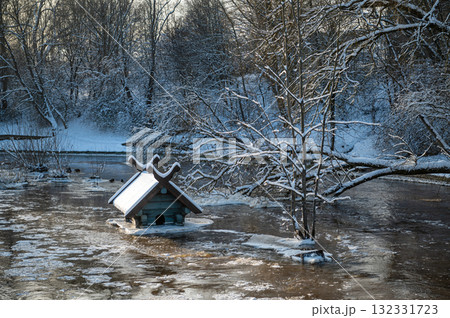spring floods and ice melt in a small river, waterfowl feeder flooded as water level rises, Dobele spring floods and ice melt in a small river, waterfowl feeder flooded as water level rises, Dobele 132331723