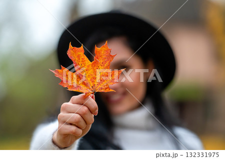 Portrait of a beautiful young woman in the autumn park with maple leaf Portrait of a beautiful young woman in the autumn park with maple leaf 132331975
