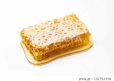 白背景に黄金色に輝くコムハニーがとろける純粋なはちみつ 132332156