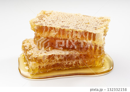 白背景に黄金色に輝くコムハニーが重なったとろける純粋なはちみつ 132332158