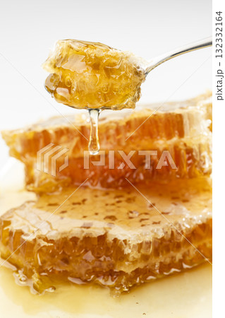 スプーンですくい上げた巣みつから滴るはちみつ スプーンですくい上げた巣みつから滴るはちみつ 132332164