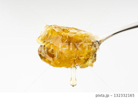 スプーンですくい上げた巣みつから滴るはちみつ 132332165
