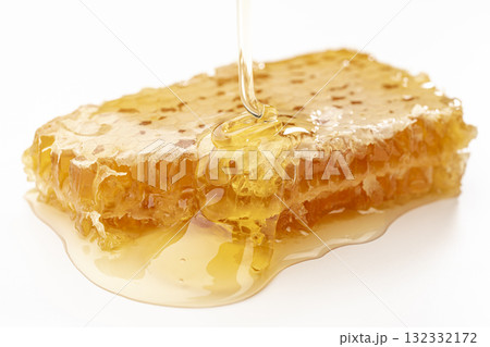 蜂の巣の上にとろりとはちみつが垂れるコムハニーのクローズアップ 132332172
