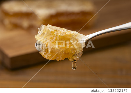 蜜が光る蜂の巣をスプーンで掬う 132332175