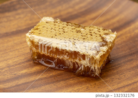 木の皿にのせた艶やかな質感のコムハニー 132332176