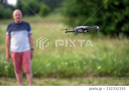 drone copter flying in the air with blurred man on background drone copter flying in the air with blurred man on background 132332191