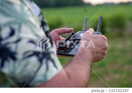 A man holding a remote control of a drone in his hand, close-up A man holding a remote control of a drone in his hand, close-up 132332197
