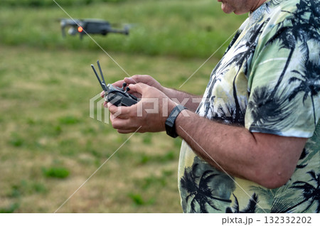 A man holding a remote control of a drone in his hand, close-up 132332202