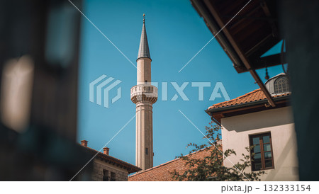 Minaret of a mosque rising against a clear blue sky in the sunlight Minaret of a mosque rising against a clear blue sky in the sunlight 132333154