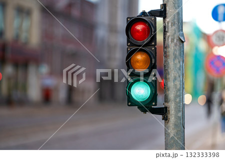 view of city traffic with traffic lights, in the foreground a semaphore with a green light, closeup 132333398
