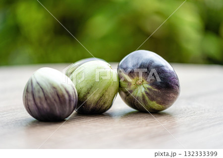 fresh and delicious tomatoes of green-black colored sort on a wooden table, closeup 132333399