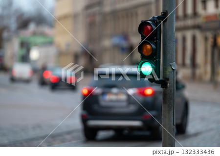 closeup of small traffic semaphore with green light against the backdrop of the city traffic 132333436