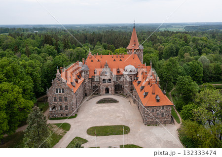 Cesvaine medieval castle in Latvia from above. Building of stones with a brown tiled roof. Cesvaine medieval castle in Latvia from above. Building of stones with a brown tiled roof. 132333474