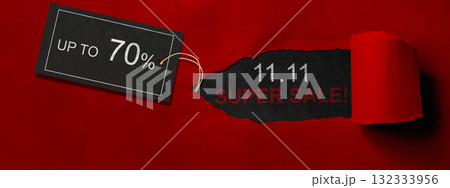 Top view of red ripped paper and text of 11.11 super sale with up to 70% text on the label tag. Copy space. Flash sale concept 132333956