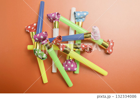 Colorful party blowers on a red background. Concept of a party or a celebration 132334086