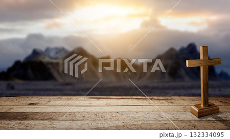 Christian cross on a wooden table with a landscape view and a dark dramatic sky background. Concept of Christianity, religious, faith, Jesus, or belief 132334095