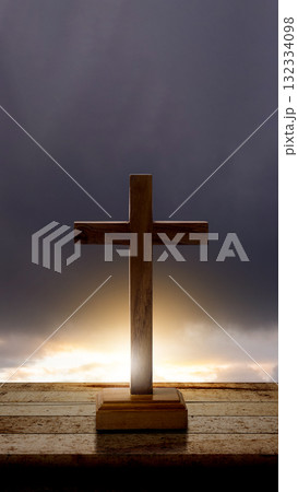 Christian cross on a wooden table with a dark dramatic sky background. Concept of Christianity, religious, faith, Jesus, or belief 132334098