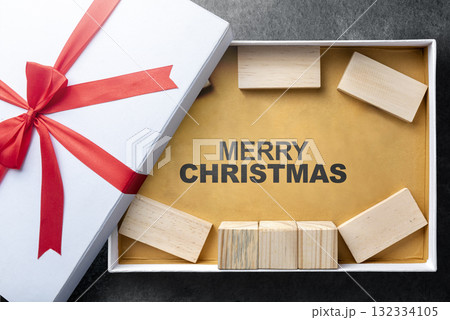 Greeting of Merry Christmas text with a wooden block in a giftbox. Mockup or Copy space. Holiday greetings or winter themes. Concept of the Merry Christmas celebration Greeting of Merry Christmas text with a wooden block in a giftbox. Mockup or Copy space. Holiday greetings or winter themes. Concept of the Merry Christmas celebration 132334105