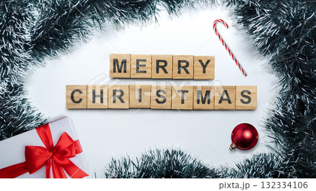 Greeting of Merry Christmas text with a giftbox and candy cane on a Christmas ornament frame on a white background. Holiday greetings or winter themes. Concept of the Merry Christmas celebration 132334106