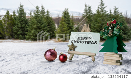 Greeting card of Merry Christmas with Christmas ornaments on the field with a snowy field background. Holiday greetings or winter themes. Concept of the Merry Christmas celebration Greeting card of Merry Christmas with Christmas ornaments on the field with a snowy field background. Holiday greetings or winter themes. Concept of the Merry Christmas celebration 132334117