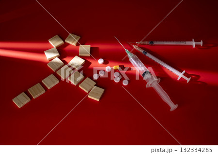 Ribbon formed by wooden cubes with a syringe and medicine. Symbolizing awareness and support for HIV or AIDS patients. Mockup or Copy space. World Aids Day. Concept of Healthcare and Medicine Ribbon formed by wooden cubes with a syringe and medicine. Symbolizing awareness and support for HIV or AIDS patients. Mockup or Copy space. World Aids Day. Concept of Healthcare and Medicine 132334285
